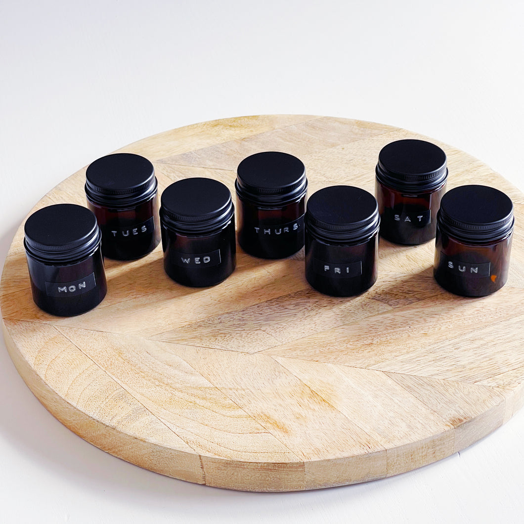 Set Of 7 Mini Amber Glass Jars With Black Lids And Stamped Labels