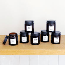 Load image into Gallery viewer, Set Of 7 Mini Amber Glass Jars With Black Lids And White Labels
