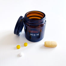 Load image into Gallery viewer, Set Of 7 Mini Amber Glass Jars With Black Lids And Stamped Labels
